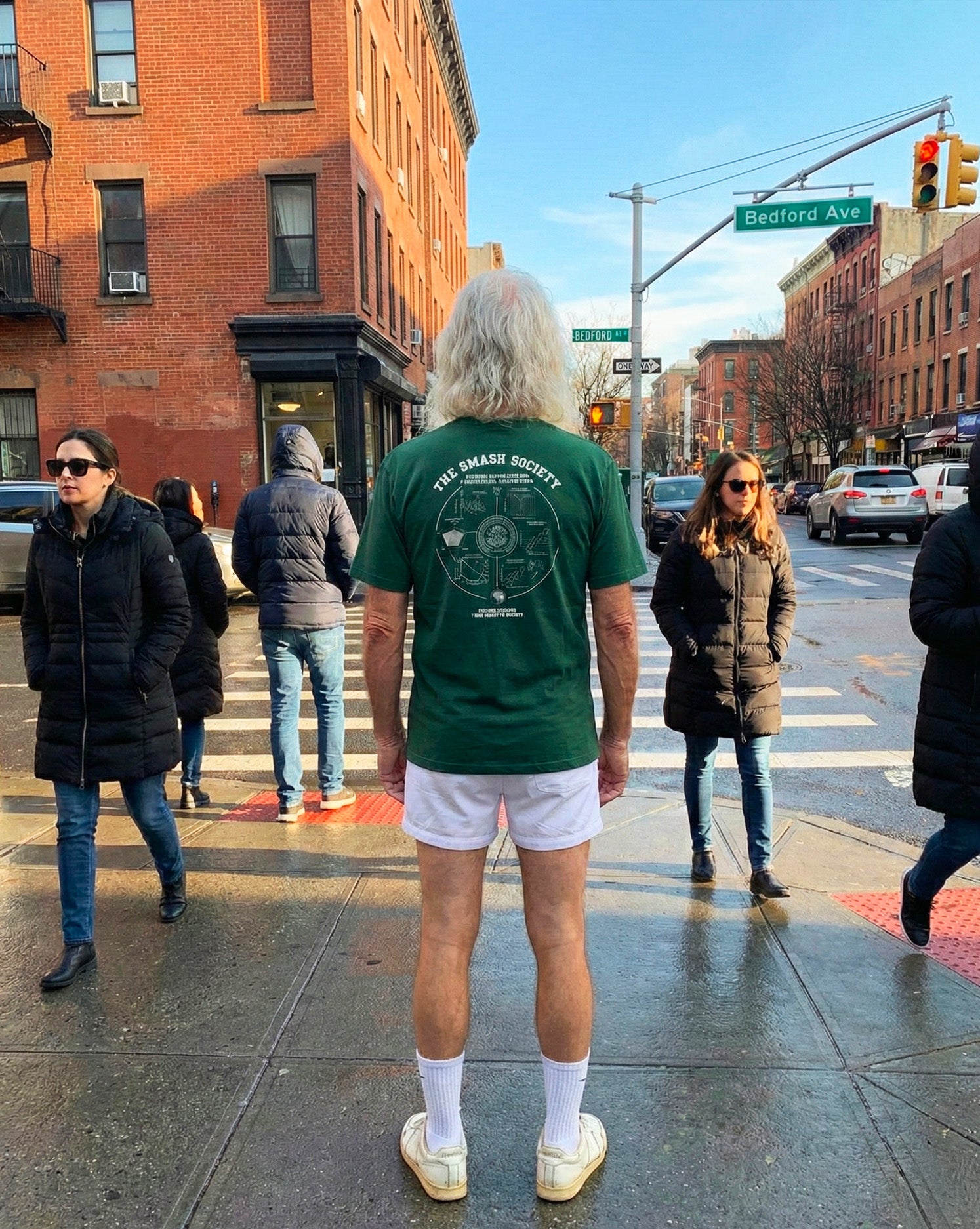 man standing in new-york and wearing a green padel t-shirt from the smash society