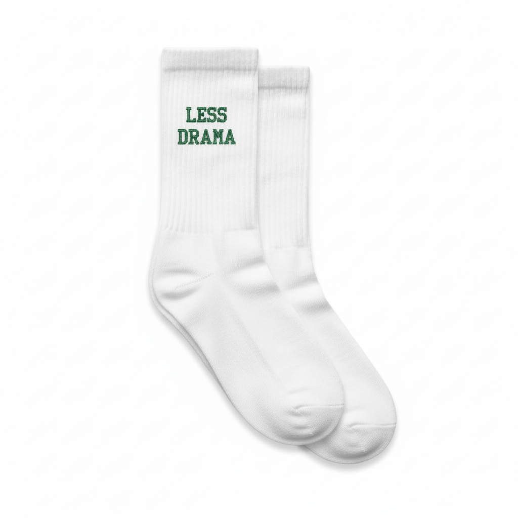 White padel socks with 'LESS DRAMA' text on a white background