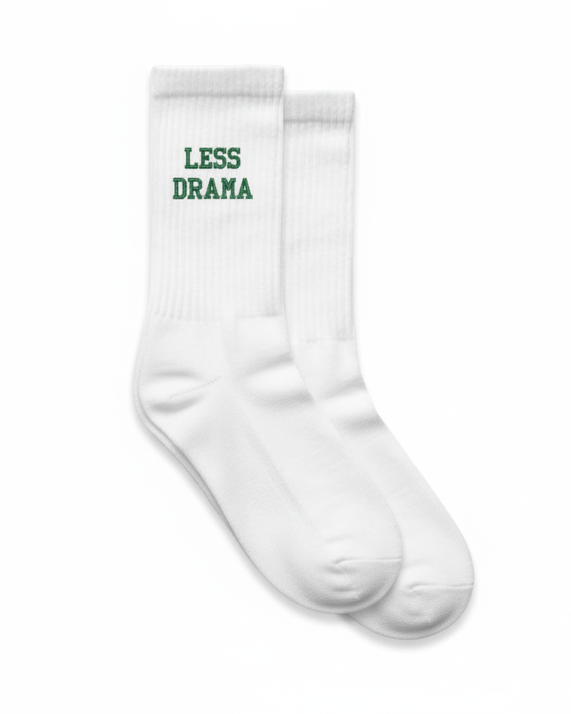 White padel socks with 'LESS DRAMA' text on a white background